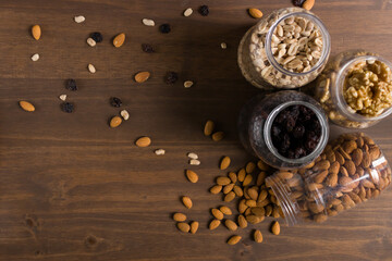 Bodegón de envases con frutos secos, nueces, almendras, maní y pasas de uva. Frascos...