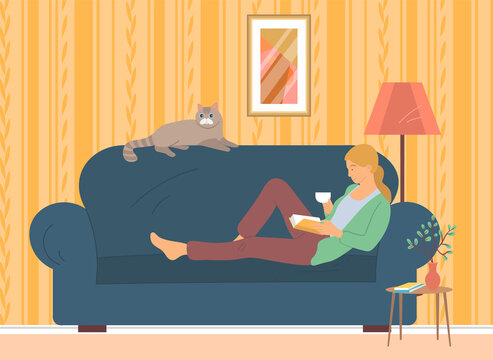 Woman lying on couch with interesting book. Girl resting at home and reading literature. Lady lies on sofa with cat and book. Person spends time on furniture. Recreation, leisure activity concept