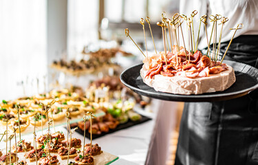 woman hands of a waiter prepare food for a buffet table in a restaurant
