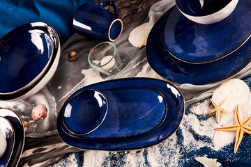 Still life composition photography of blue tableware ceramic utensils and white sand