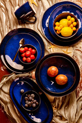 still life photography of fruits and blue cutlery