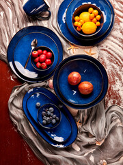 still life photography of fruits and blue cutlery