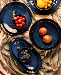 still life photography of fruits and blue cutlery