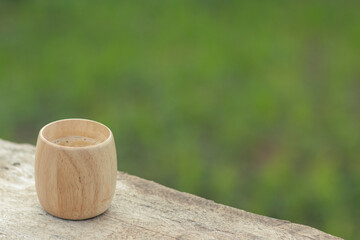 selective focus, bamboo coffee cup, beautiful shape, placed on a wooden balcony The natural background has space for text.