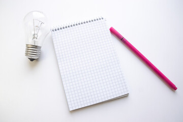Notepad, marker and light bulb on a white background. concept idea