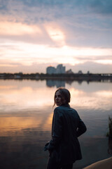 Fototapeta premium Portrait of a young woman in nature with sunset light. People, lifestyle, relaxation and vacations concept. 