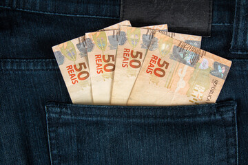 Finance concept. Brazilian fifty reais banknotes in the pocket of jeans - Powered by Adobe