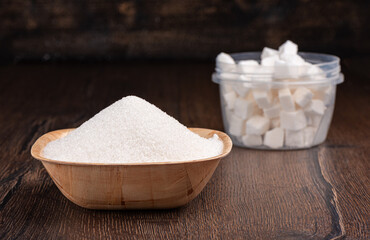 Bowl with white sugar on a wooden background.