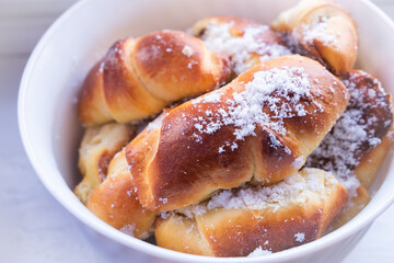 sweet buns with powdered sugar plate close-up