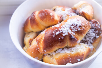 sweet buns with powdered sugar plate close-up