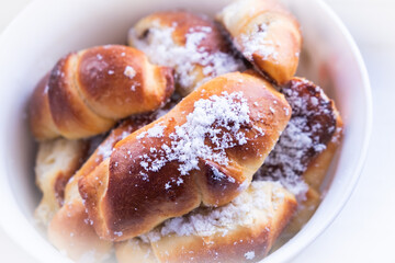 sweet buns with powdered sugar plate close-up