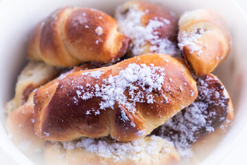 sweet buns with powdered sugar plate close-up