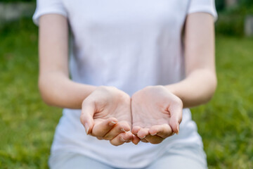 Girl wearing mockup white t-shirt with hands outstretched showing empty palms. Giving held out....