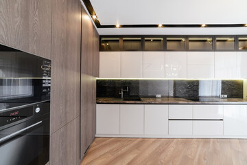 interior of the new white kitchen with dark floors and dark furniture