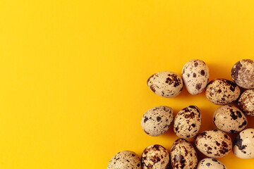 Quail eggs lays on yellow paper background with copy space or empty place for text. Easter holiday. Visiting card. Religious layout. Springtime design. Healthy food product. Farm organic production