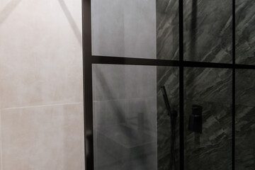 glass wall in a shower with black metal