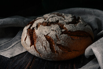 Homemade rye bread. Rye bread in a round shape on a wooden background in a rustic style with towel