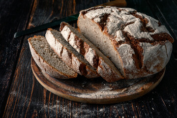 Homemade rye bread. Sliced rye bread in a round shape on a wooden background in a rustic style.
