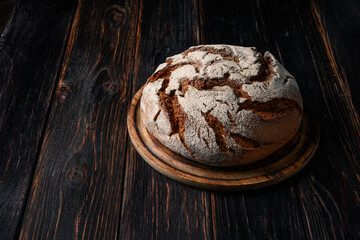 Homemade rye bread. Rye bread in a round shape on a wooden background in a rustic style
