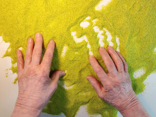 sand therapy, hands of an elderly woman on green kinetic sand, the concept of rehabilitation of the...