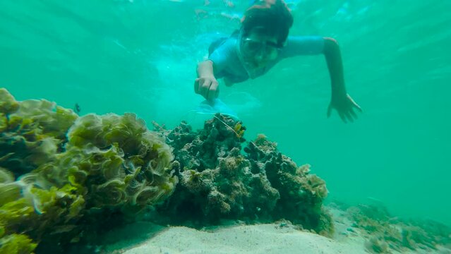 A boy in an underwater mask cleans the seabed from pollution. The concept of nature conservation.