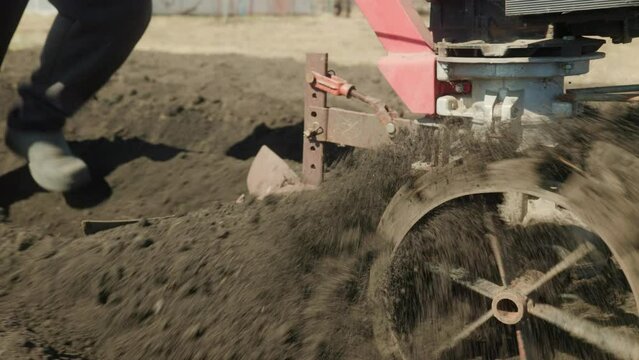 Motoblock. walk-behind tractor Man with walk-behind tractor plows the ground