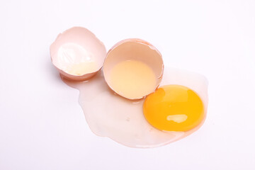 top view Cracked egg isolated on a white background with clipping path. Fresh spilled chicken eggs with whole yolk. selective focus
