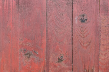 Old wooden worn fence boards weathered texture in peeling red paint dirty obsolete background