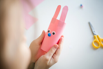 easter paper craft for kids. child girl making banny in kindergarten in spring