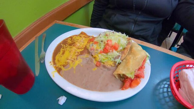 The Lunch Special at the local Mexican restaurant, includes beef taco, chalupas, enchilada with cheese and refried beans; concept of restaurant, ethnic food, friendship and family