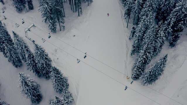 Aerial top-down shot of the lone skier on the ski slope in the Arosa ski resort in Switzerland - no people due to the sanctions against Russian tourists after the invasion of Ukraine
