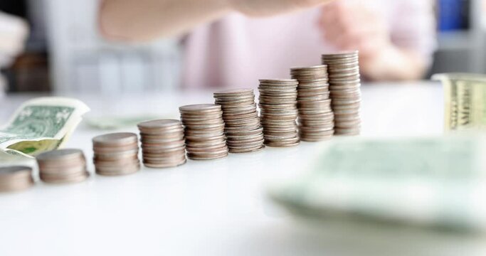 Successful leader runs hand over stacks of coins in ascending order