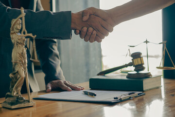 Male lawyer with client shaking hands in the office Businessmen shake hands to seal a deal with a partner lawyer or a lawyer who discusses a contract agreement.