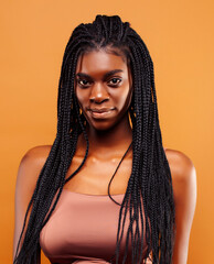 pretty young african american woman with braids posing cheerful gesturing on brown background, lifestyle people concept - obrazy, fototapety, plakaty