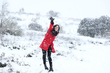 Woman dressed in red enjoys in the snow.