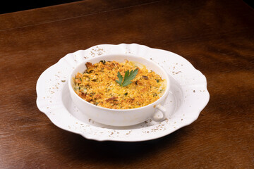 fish casserole with parsley and farofa angle view on wooden table