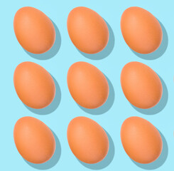 Easter Egg pattern: raw chicken eggs on blue background. Top view, healthy food.
