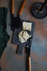 Blue cheese on slate board, cheese knives on rust old heavily worn black navy blue concrete texture...