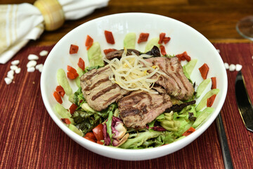 A salad is a dish consisting of mixed, mostly natural ingredients with at least one raw ingredient. 