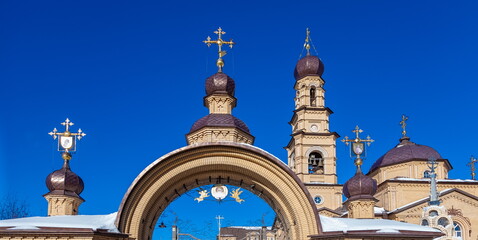 Obraz premium The building of the Orthodox church on the background of blue sky with white clouds in winter. Russia. Ural. Kurganovo