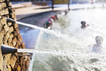 a jet of salt water beats out of stone and from underground at a spa resort in winter it is not cold