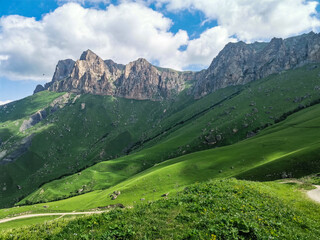 The landscape of the green Aktoprak pass in the Caucasus, the road and the mountains under gray clouds. Russia.