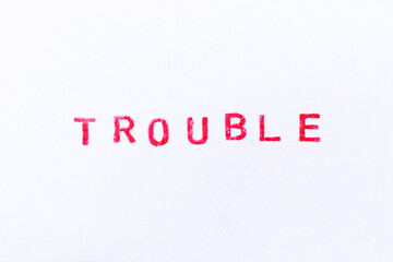 Red color ink rubber stamp in word trouble on white paper background