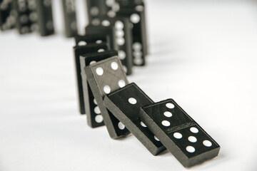 Black dominoes chain on white table background