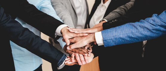 Multicultural business people stacking hands with colleagues inside modern office - Focus on African man hands
