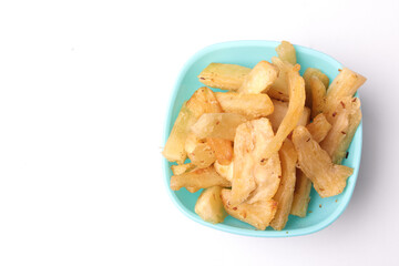 selective focus of fried cassava in blue bowl on white background, copy space, texture, Indonesian food.