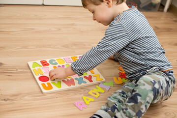Baby early learning. Wooden letters of the alphabet. Children reading puzzle. Kids educational game, match the right place. Teaching develop intellectual kid game board.