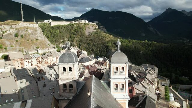 Nice old village with old church at bottom of forested hill. Aerial shot flying low of Briancon, one of France historical towns, in autumn
