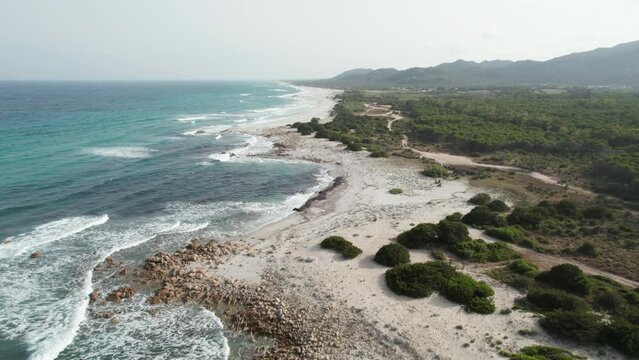 Aerial view drone over beach sea with powerful sea waves. Beach sand and amazing sea in summer. Sardinia, Italy, Berchida