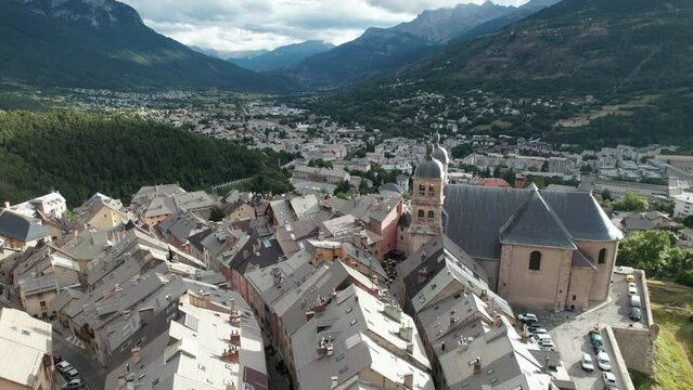 Nice old village with old church at bottom of forested hill. Aerial shot flying low on the buildings of Briancon, one of France historical towns, in autumn